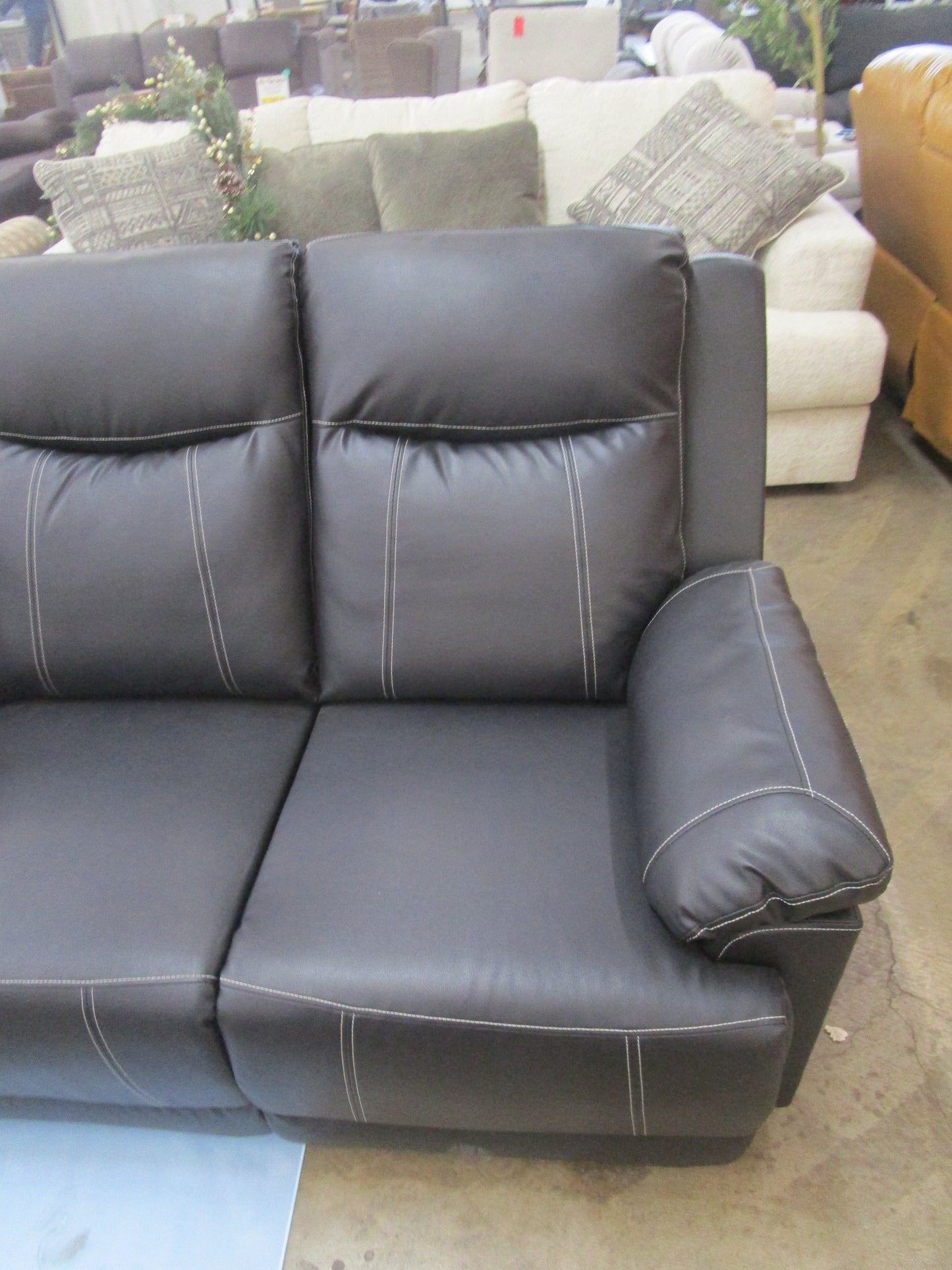 Black flaux leather sofa with cup holder.