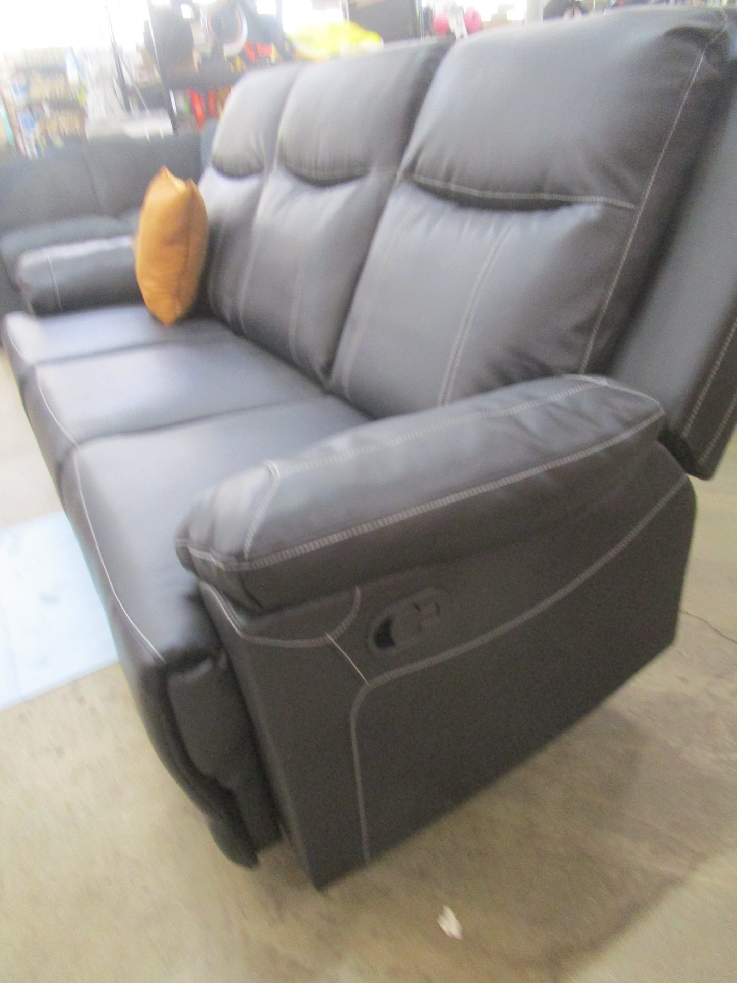 Black flaux leather sofa with cup holder.